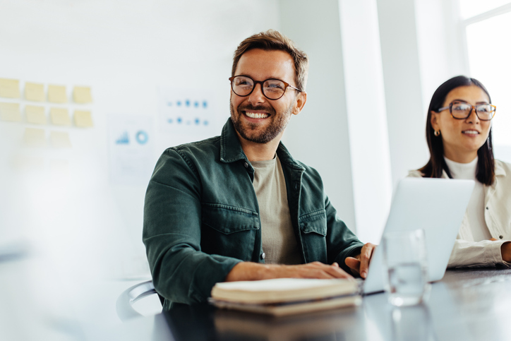 Male employee on computer smiling