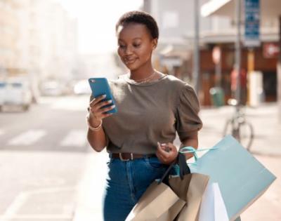 Woman with shopping bags looking at phone