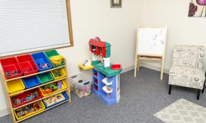 Therapy office with children's toys, easel and chair
