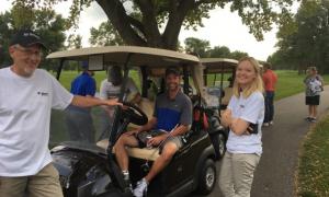 Volunteers surround a golf cart at the 2018 Bobcat ND Open