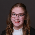 Headshot of Rachel Fischer, a white woman with glasses and curled, medium brow hair