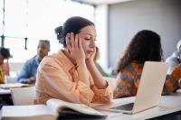 Woman sitting at computer desk looking stressed