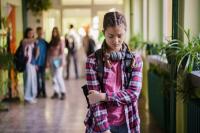 Girl crossing arms in the hallway getting bullied